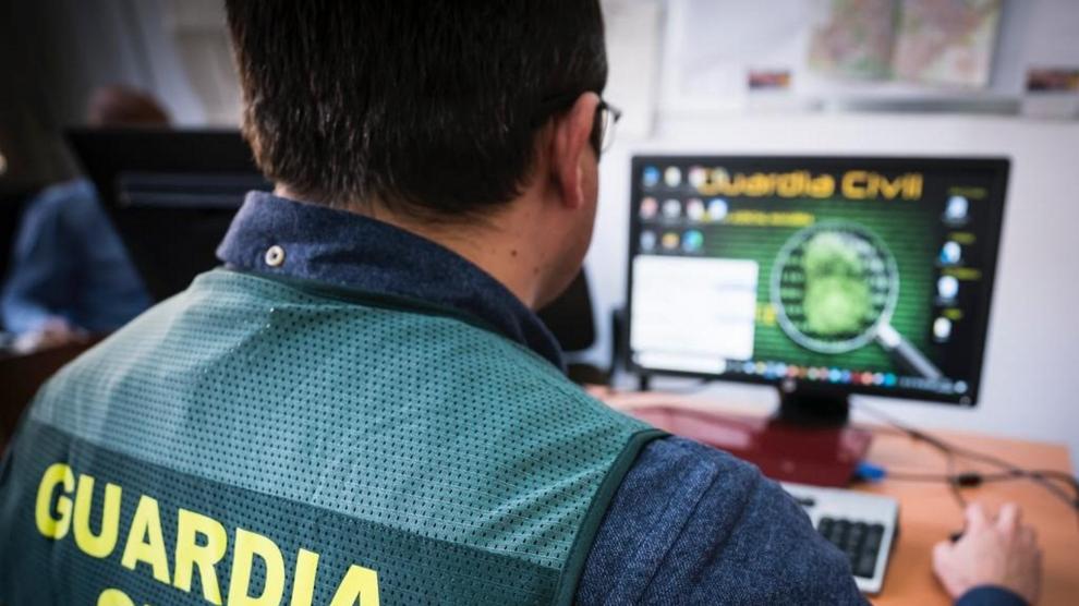 un agente de la guardia civil trabajando en un ordenador